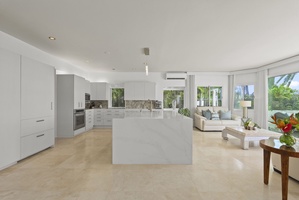 This entertainer’s kitchen flows into a luminous living area, combining modern design with effortless comfort.