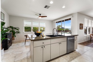 Large windows and modern finishes define this open kitchen layout.