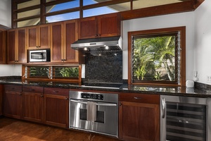 Fully equipped kitchen with stainless steel appliances and garden views.