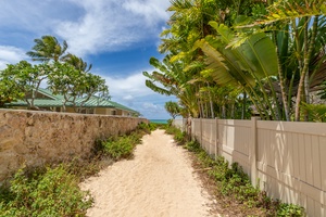 The sandy path leads to turquoise waters