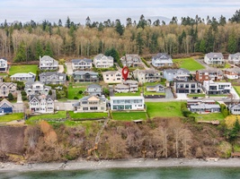 Waterfront community with modern homes nestled among forested hills, featuring a peaceful shoreline and well-maintained neighborhood streets.