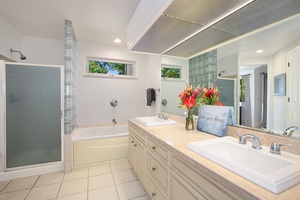 Primary ensuite bathroom with double vanity and a cozy soaking tub.
