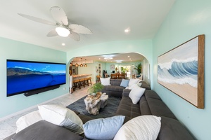 Plush sectional seating with ocean-inspired decor and a large flat screen for relaxing nights.
