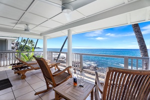 Covered primary bedroom lanai with lounge seating and uninterrupted views of the ocean’s edge.