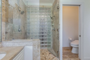 Primary ensuite bathroom with walk-in shower and natural stone finishes for a spa-like experience.