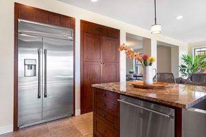Sleek kitchen corner with modern appliances and elegant wood finishes.