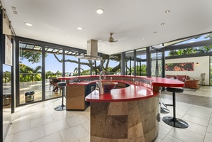 The bold ruby-red kitchen island offers seating for twelve, making it the heart of the home.