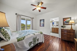 Bright guest bedroom with large windows, ceiling fan, and tropical quilted bedding—perfect for restful nights in island comfort.