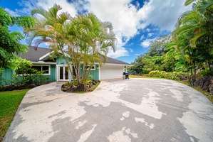 Welcoming driveway framed by tropical palms, offering ample parking and a warm first impression upon arrival.