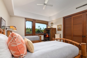 Unwind in your tropical retreat with twin beds, cozy fireplace, and serene garden views framed by warm wood details.