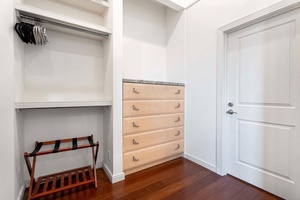 Walk-in closet with built-in drawers and open hanging space.