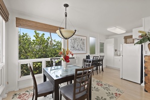 Gather around your elegant dining table for memorable meals, with natural light streaming through bamboo shades and garden views beyond.