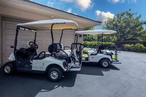 Two golf carts parked outside the property garage, ready for exploring the surrounding area.