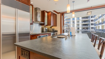 There is a fully equipped kitchen with stainless steel appliances.