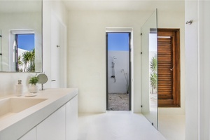 Sleek ensuite bathroom with easy access to an outdoor shower.