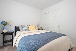 This bright and inviting guest bedroom offers closet space and soft linens, creating a welcoming spot for younger guests or friends.
