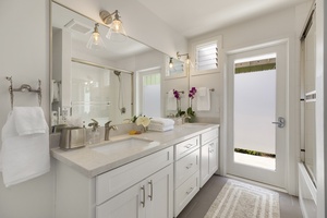 Back House Hallway Bathroom with Tub, Double Vanity, and Door to Outdoor Shower