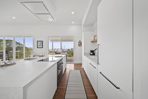 Prepare meals in the sleek, open kitchen while enjoying lush outdoor scenery.