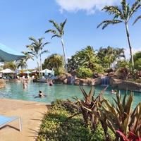 The lagoon and pool area combine lush landscaping with a refreshing swimming experience under the Kauai sun.