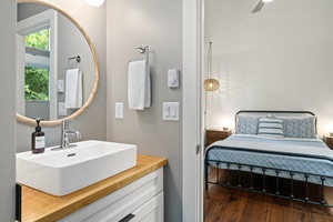 Crisp and clean with a modern vanity and circular mirror for easy mornings.