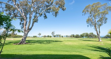 Catch a glimpse of the shimmering Pacific just beyond the greens—your own slice of island paradise awaits.