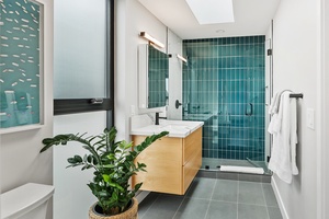 Upstairs bathroom with glass shower and a single vanity space.