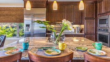 Sizeable kitchen island with bar seating and chic modern lighting.