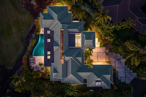 Aerial view of Canoe House at Champion Ridge, a luxurious home at dusk, with warm lighting and a private pool.