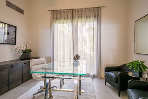 Bright and modern office space featuring minimalist decor and large windows for natural light.