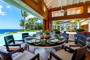 Dine al fresco by the pool, with a stylish round dining table and spectacular views of the ocean and lush surroundings.