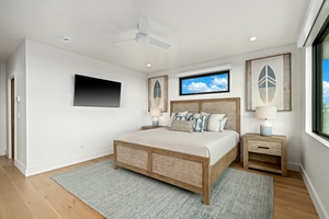 Drift off in your serene bedroom with coastal charm, featuring a plush king bed and wall-mounted TV for cozy evenings.