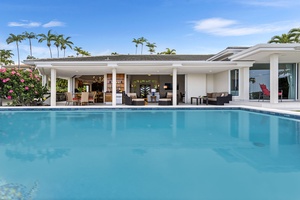 Infinity-edge pool framed by palm trees and panoramic views of the Kona coastline.