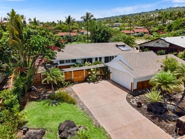 The drive and grounds open up from above, palms shading the approach.