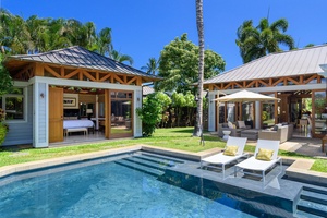 The pool area with poolside sun loungers adjacent to the open living room and third bedroom suite.