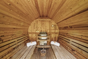 Interior of the cedar-lined sauna with benches and traditional stove—luxury in a natural setting.