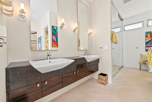 Primary bath with dual sink and vanity mirrors.