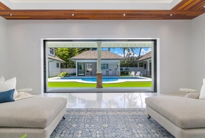 Poolside lounge room with wide-opening doors for seamless indoor-outdoor living.
