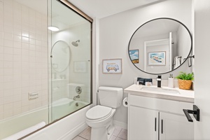 Bright and modern bathroom with a full tub—ideal for a calming soak after a beach day.