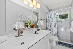 Communal bathroom with dual sink and a walk-in shower