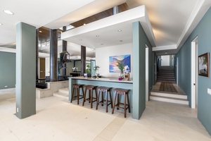 Gather around your bar where limestone meets modern design, creating the perfect space for morning coffee or evening cocktails.