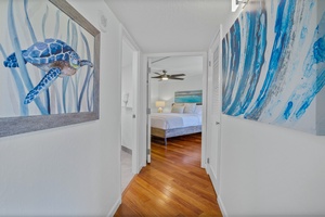 A sunny hallway with wood floors leads to the peaceful bedroom at Kaanapali Shores 213.