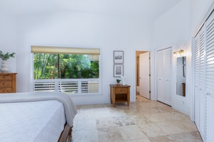 King bedroom with garden views, ceiling fan, and clean design for a peaceful night’s sleep.