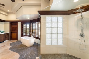 The spa-like primary bathroom features a walk-in shower and organic textures with elegant privacy.