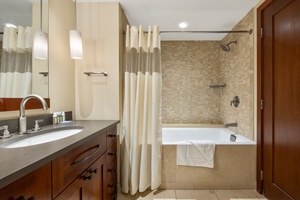 Unwind in your spa-like bathroom with a deep soaking tub, elegant mosaic tiles, and luxurious amenities for ultimate relaxation.
