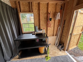 Functional shed with a workbench and tools neatly organized.