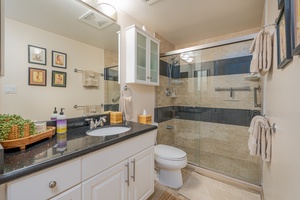 With an ensuite bathroom with a walk-in shower in a glass enclosure.