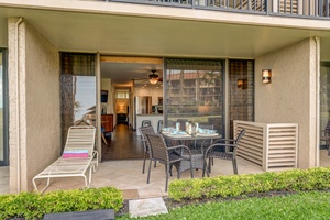 Lounge outdoors at Papakea B-105 with a shaded dining set and relaxing garden views.