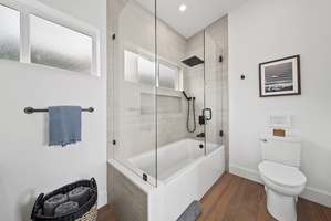 Glass-enclosed shower-tub combo for a relaxing soak after a day of adventure.