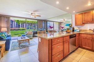 The kitchen at Papakea K-105 opens to light-filled spaces with calming views of lush garden greenery.