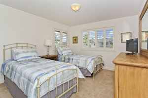 The second guest bedroom with beds and a dresser.